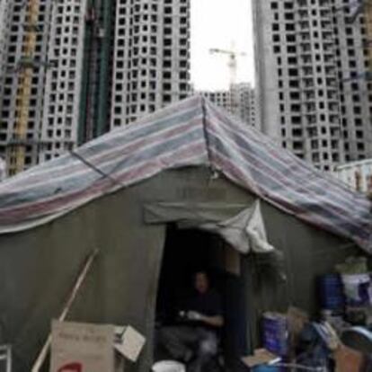 Un obrero descansa frente a un edificio en construcción en Pekín