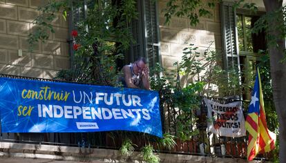 Un vecino, en Barcelona, en su balcón con banderas independentistas.
