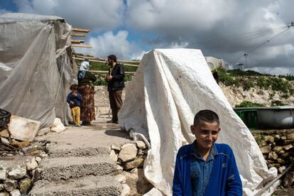 Plástico y madera son los materiales con los que todas las familias asentadas en zonas agrícolas han construido sus casas. En la imagen, un técnico de Acción Contra el Hambre atiende a una refugiada siria mientras sus hijos juegan junto alrededor. Asentamiento de Babliyi, cerca de Saida, sur de Líbano.