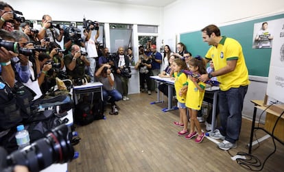 Um pai e suas filhas sorriem para os fotógrafos no colégio eleitoral onde vota Aécio Neves, em Belo Horizonte.