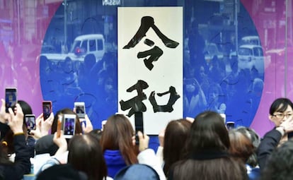 Un grupo de ciudadanos toma fotos de una pancarta con la caligrafía de la nueva era imperial, 'Reiwa' en Tokio, el pasado 1 de abril.