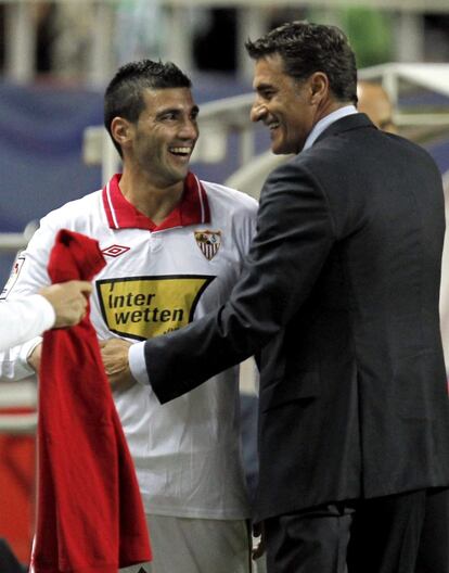 El entrenador del Sevilla Míchel felicita a Reyes.