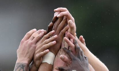 Jugadores del equipo sudafricano de rugby masculino unen sus manos durante una sesión de entrenamiento en Río de Janeiro (Brasil).