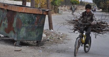 Un chico transporta madera en el este de Ghouta.