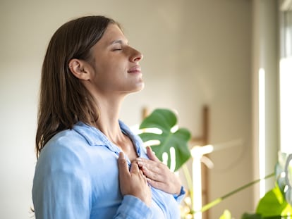 Una joven practica ejercicios de respiración.