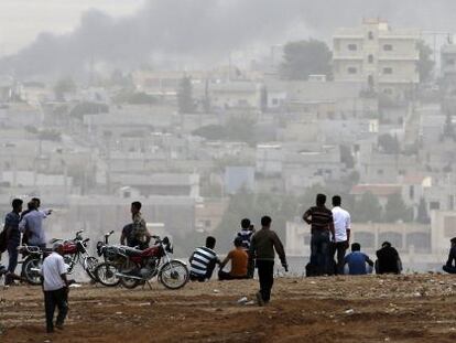 Turcs kurds observen la ciutat de Kobane (Síria).