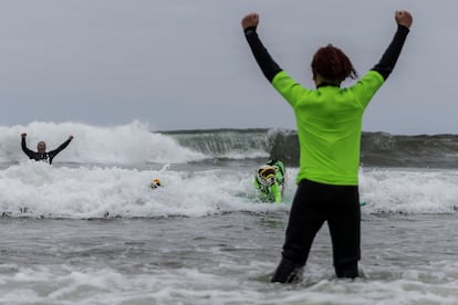 El perro Faith, de 10 años, ganó la categoría de perros grandes en solitario. En la imagen, James Wall, el dueño de Faith, celebra después de que su mascota surfeara una ola.