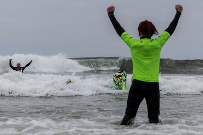 El perro Faith, de 10 años, ganó la categoría de perros grandes en solitario. En la imagen, James Wall, el dueño de Faith, celebra después de que su mascota surfeara una ola.