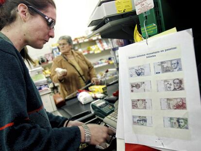 Una cajera de una tienda de comestibles cobra los productos en pesetas en Villamayor de Santiago.