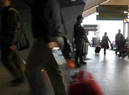 Un antidisturbios armado con una escopeta vigila en una entrada de la terminal T-4 del aeropuerto de Barajas.