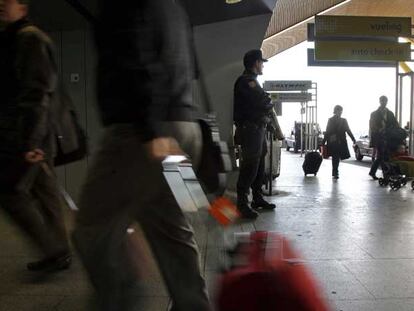 Un antidisturbios armado con una escopeta vigila en una entrada de la terminal T-4 del aeropuerto de Barajas.