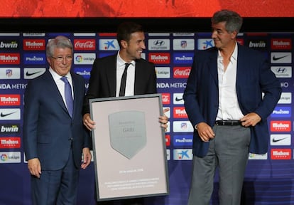 Gabi posa con una placa conmemorativa junto a Enrique Cerezo y Miguel Ángel Gil Marín durante su acto de despedida en el Wanda Metropolitano.