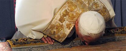 El Papa besa la piedra donde se cree que se lavó el cadáver de Cristo antes de darle sepultura.