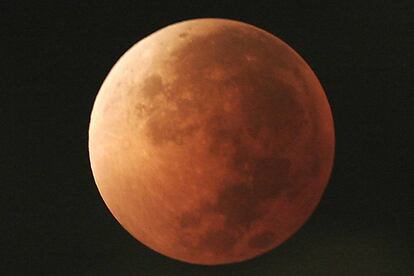 FILE - In this Aug. 28, 2007, file photo, the moon takes on different orange tones during a lunar eclipse seen from Mexico City. During a lunar eclipse, the moon's disk can take on a colorful appearance from bright orange to blood red to dark brown and, rarely, very dark gray. On Wednesday, Jan. 31, 2018, a super moon, blue moon and a lunar eclipse will coincide for first time since 1982 and will not occur again until 2037. (AP Photo/Marco Ugarte, File)