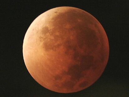 FILE - In this Aug. 28, 2007, file photo, the moon takes on different orange tones during a lunar eclipse seen from Mexico City. During a lunar eclipse, the moon's disk can take on a colorful appearance from bright orange to blood red to dark brown and, rarely, very dark gray. On Wednesday, Jan. 31, 2018, a super moon, blue moon and a lunar eclipse will coincide for first time since 1982 and will not occur again until 2037. (AP Photo/Marco Ugarte, File)