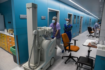 Dos técnicos de radiología acuden a realizar una exploración de tórax a uno de los enfermos ingresados. Durante la pandemia se extendió el uso de equipos móviles de rayos para poder seguir la evolución de los pacientes en el mismo lugar donde se encontraban. La radiografía era la primera prueba que se les practicaba cuando llegaban a Urgencias. Las placas se interpretaban en el momento y se enviaban al médico que recibía al enfermo.