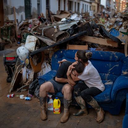 Tania hugs her brother-in-law Baruc after rescuing some of their belongings from their flooded house after the floods in Paiporta, Valencia, Spain, Tuesday, Nov. 5, 2024. (AP Photo/Emilio Morenatti)