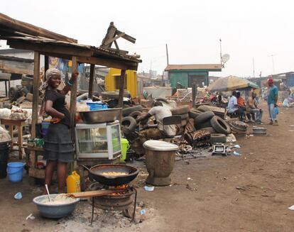 Una joven kayayei cocina en pleno mercado de Agbogbloshie