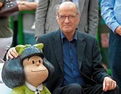 Quino posa en 2009 junto a la escultura de Mafalda en Buenos Aires, frente a la casa donde creó al emblemático personaje.