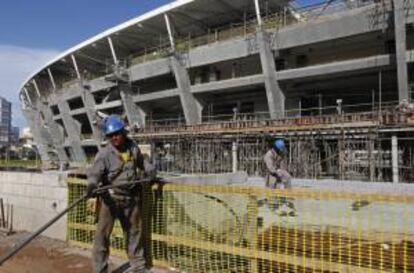 Trabajadores tienden un cable en las obras en el estadio Arena Fonte Nova en Salvador (Brasil). EFE/Archivo