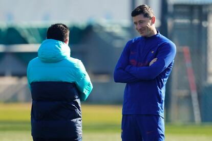 Xavi (de espaldas) conversa con Robert Lewandowski durante el último entrenamiento del Barcelona.