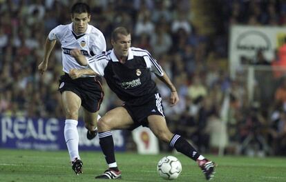 Zidane controla el bal&oacute;n con Albelda detr&aacute;s.