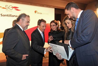 Ignacio Polanco, presidente del Grupo PRISA, Emiliano Martínez, presidente de Santillana y Pilar del Río, viuda del escritor José Saramago, muestran a los príncipes de Asturias la nueva edición de <i> El viaje del elefante. </i>
