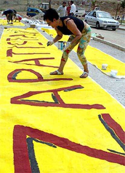 Un militante antiglobalización prepara una pancarta en Salónica.