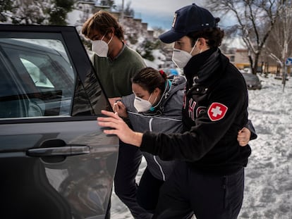 Miguel Benzo (gorra) y Rodrigo Álvarez de Toledo ayudan este domingo a Ana González, "Triana" a subir a un Land Rover para llevarla al Hospital de La Paz, en Madrid.