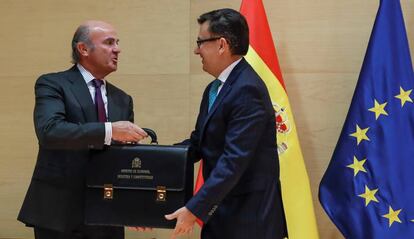 Luis de Guindos le entrega la cartera al nuevo ministro de Economía, Román Escolano.
