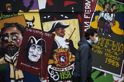 Un hombre camina delante de unos carteles de San Fermín, este martes en Pamplona.