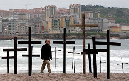 Varios miles de personas, que acudieron a la convocatoria de Nunca Máis, plantaron ayer cruces en la playa de Riazor, en A Coruña, para simbolizar la muerte del mar como consecuencia de la marea negra provocada por el <b><i>Prestige</b></i>.