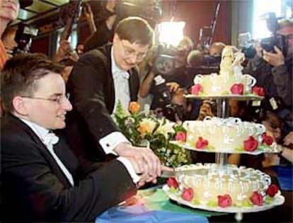 Angelika Baldow (sentada) y Gudrun Pannier parten su pastel de boda en Berlín.