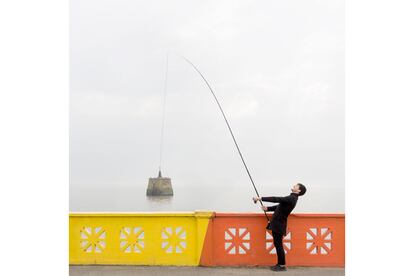 "Esto es también Argentina, en el Río de la Plata, en una zona donde debía haber buena de pesca porque estaba llena de gente con cañas. Lo cierto es que sabíamos que esta barandilla, que bordea kilómetros de río, tenía esa celosía, pero ese tramo, además, tenía colores. ¿Se ve esa pequeña construcción en el agua? No sé lo que era ni qué función tiene, pero nos dio juego. La caña de pescar nos la prestó un señor que estaba allí mientras hacíamos nuestro juego de perspectiva. Siempre pedimos cosas y la gente se presta muy amable cuando les contamos el proyecto".