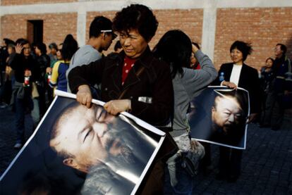 Asistentes a la fiesta sostienen una imagen de Ai Weiwei ante el estudio de este en Shanghái.