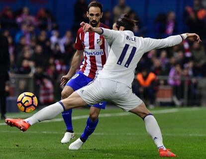 Gareth Bale (en primer plano) del Real Madrid presiona a Juanfran del Atlético de Madrid.