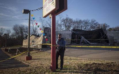 Un policía acordona este sábado un comercio incendiado en Ferguson.