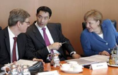 La canciller alemana, Angela Merkel (dcha), conversa con el ministro de Economía, Philipp Rösler (c), y con el responsable de Exteriores, Guido Westerwelle (izq), antes del inicio de la reunión del Consejo de Ministros en la Cancillería en Berlín (Alemania) hoy, miércoles 27 de junio de 2012.