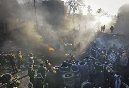 Manifestantes permanecen junto a una barricada mientras respetan una tregua con la policía en Kiev (Ucrania), 24 de enero de 2014. 