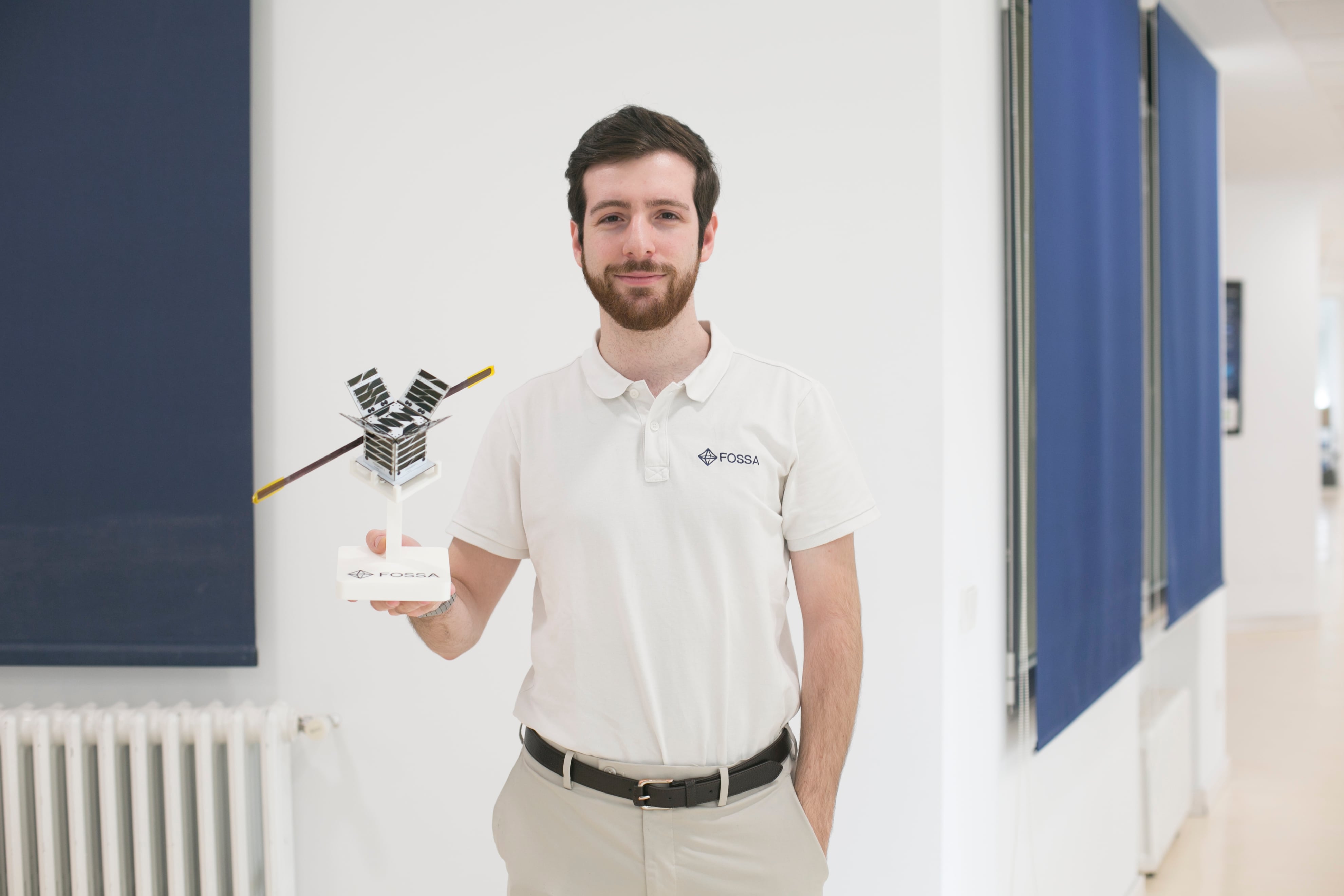 Julián Fernández sostiene una réplica del picosatélite que lanzó.