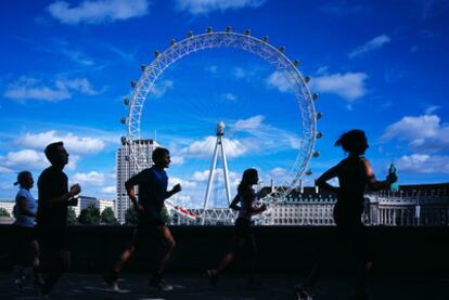 Corredores en la ribera del río Támesis, en Londres, con la noria London Eye al fondo.