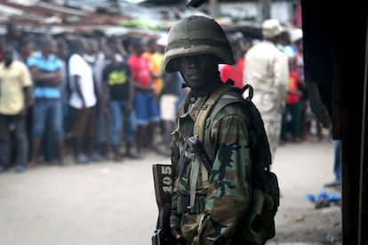 MONROVIA, LIBERIA - AUGUST 20: Members of Liberia's Ebola Task Force enforce a quarantine on the West Point slum on August 20, 2014 in Monrovia, Liberia. The military began enforcing a quarantine on West Point, a congested favela of 75,000, fearing a spread of the Ebola epidemic in the capital city. Liberian soldiers were also sent in to extract West Point Commissioner Miata Flowers and her family members after residents blamed the government for setting up a holding center for suspected Ebola patients in their community. A mob overran and closed the facility on August 16. The Ebola virus has killed more than 1,200 people in four African nations, more in Liberia than any other country. (Photo by John Moore/Getty Images)