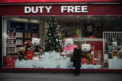 Una mujer espera junto al escaparate de un Duty Free de Andorra la Vella.