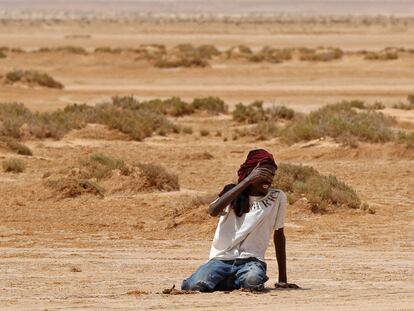 Un migrante de origen africano se desploma por agotamiento y deshidratación a su llegada a una zona deshabitada cerca de al-Assah, en la frontera entre Libia y Túnez, el pasado 30 de julio.