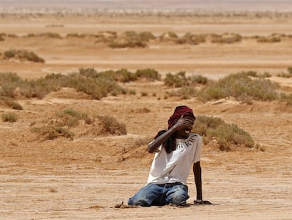 Un migrante cae al suelo por cansancio y deshidratación en el desierto entre Libia y Túnez, el pasado julio.