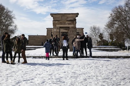 Un grupo de personas se fotografía junto al Templo de Debod, en el parque del Oeste. Un dispositivo de 6.220 personas, de las que 200 son de la Unidad Militar de Emergencias (UME) y 135 máquinas quitanieves trabajan en 115 calles de los 21 distritos de la capital para tratar de retirar la nieve y sacar a Madrid del colapso producido por 'Filomena'.