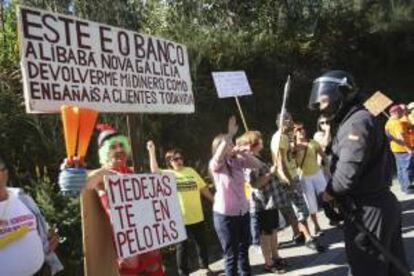 La Policía vigila al más del centenar de afectados por las participaciones preferentes y subordinadas de Novagalicia Banco que protestan desde primera hora de la mañana en los accesos al castillo de Soutomaior, donde el presidente del Gobierno, Mariano Rajoy, participará en un acto del PP.