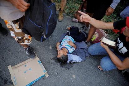 Un niño descansa en el piso rodeado de otros migrantes que vienen en la caravana que se dirige a Estados Unidos.
