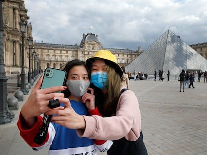 Dos mujeres con máscara protectora ante el Museo del Louvre en París, el 6 de marzo