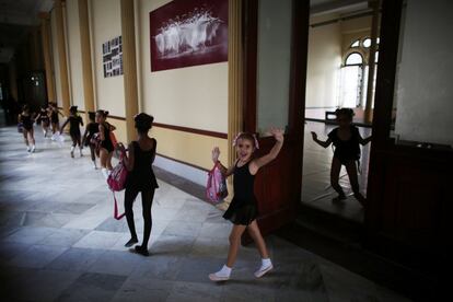 Una niña saluda a la cámara tras salir de una clase.